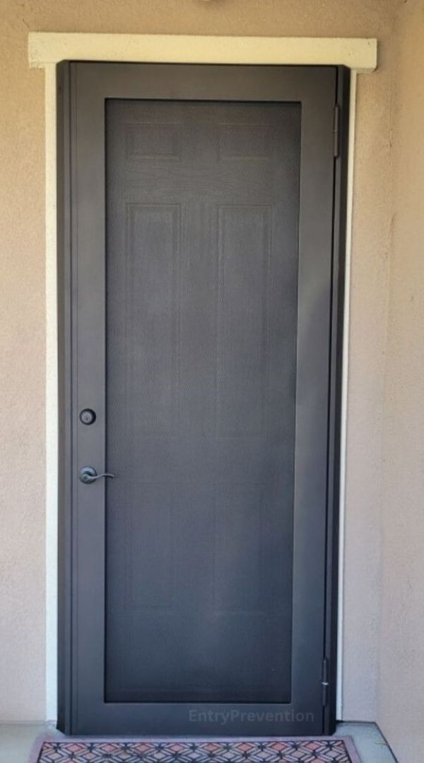 Brown single security screen door installed on a home